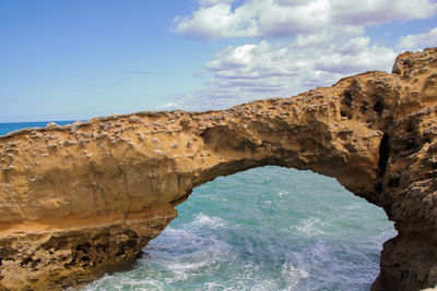 Rock formations by sea against sky