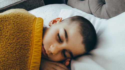 Close-up of boy sleeping on bed at home