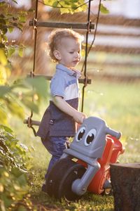 Portrait of boy playing with toy on field