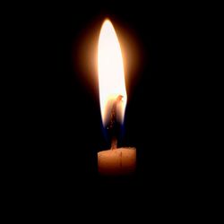 Close-up of burning candle in darkroom