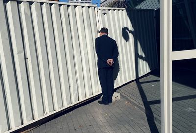 Rear view of man standing at gate