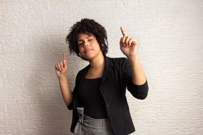 Portrait of woman standing against wall