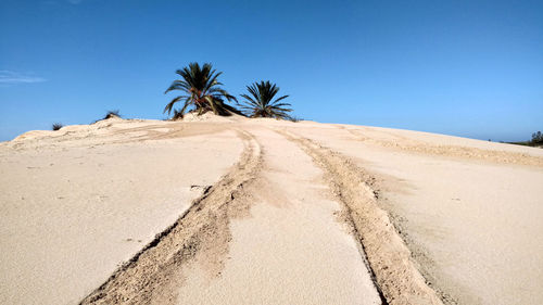 Scenic view of desert against clear blue sky