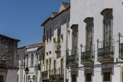 Low angle view of buildings against clear blue sky