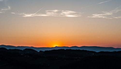 Scenic view of silhouette mountains against romantic sky at sunset