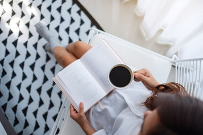 High angle view of woman holding coffee cup