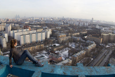 High angle view of woman sitting against buildings in city