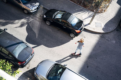 Man wearing horse mask while skateboarding amidst cars on street in city