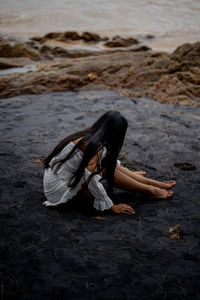 Woman sitting on shore at beach