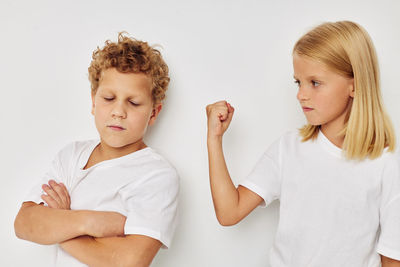 Sister arguing with brother against white background