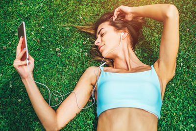 Midsection of woman lying on grass