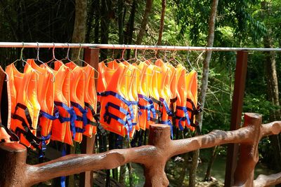 Various flags hanging on railing by fence