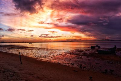 Scenic view of sea against dramatic sky during sunset