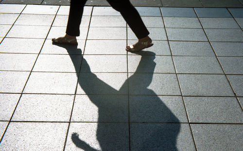 Low section of woman walking on tiled floor