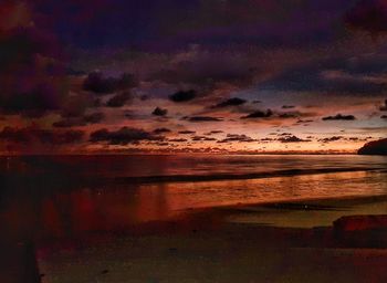 Scenic view of sea against dramatic sky during sunset
