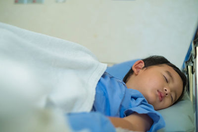 Boy sleeping on bed in hospital