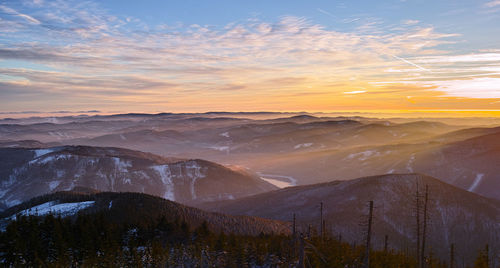 Scenic view of snowcapped mountains against sky during sunset