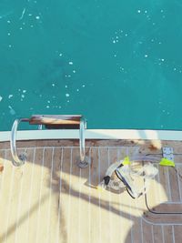 High angle view of snorkel and swimming goggles on boat deck in sea