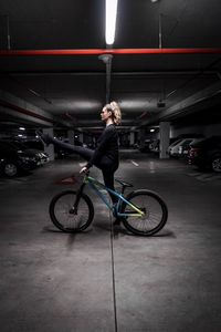 Man with bicycle standing in parking lot