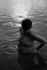 Rear view of shirtless boy in lake