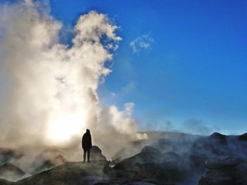 Rear view of silhouette woman standing on mountain