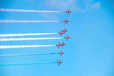 Low angle view of airshow against sky