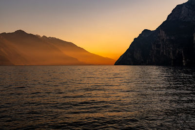 Scenic view of sea and mountains against sky during sunset