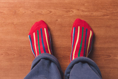 Low section of person wearing socks on wooden floor