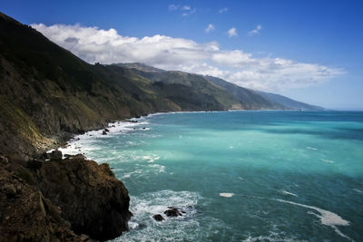 Scenic view of sea and mountains against sky