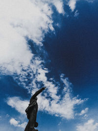 Low angle view of bird flying against blue sky