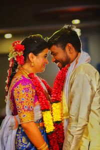 Midsection of couple with pink flowers against blurred background