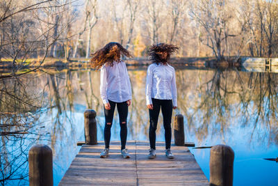 Rear view of friends standing against bare trees