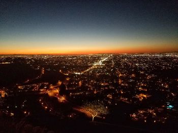 Aerial view of illuminated cityscape against sky at night