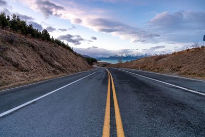 Mount cook road alongside lake pukaki with snow capped southern alps in winter evening light. 