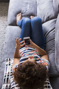 Midsection of woman using mobile phone while sitting on laptop