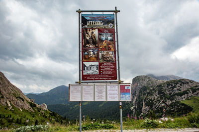 Information sign on mountain against sky