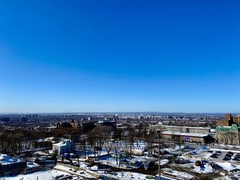 High angle view of buildings against clear blue sky