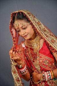 Beautiful young bride standing against wall