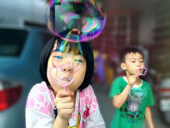 Siblings blowing bubbles outdoors