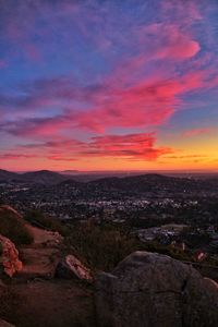 Scenic view of landscape against dramatic sky during sunset