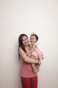 Portrait of a smiling young woman against white background