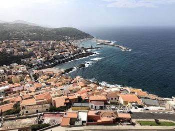 High angle view of townscape by sea against sky