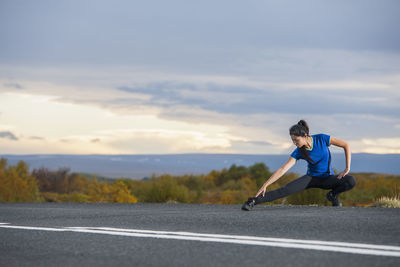 Beautiful woman stretching during work out in rural area in iceland