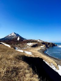 Scenic view of beach against clear blue sky