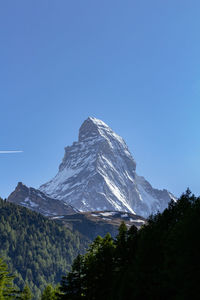 Scenic view of snowcapped mountains against clear blue sky