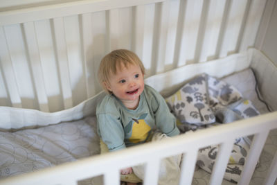 High angle view of cute baby boy lying on bed at home