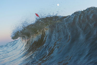 Close-up of sea waves splashing against sky