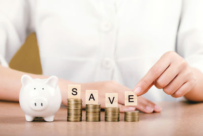 Cropped image of hand holding coins on table