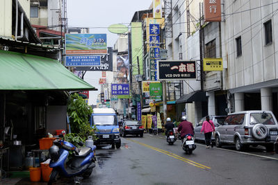 Cars on road by buildings in city