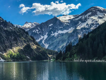 Scenic view of lake by mountains against sky